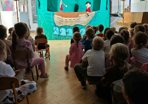 Dzieci oglądają przedstawienie teatralne.