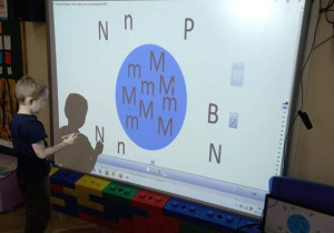 Dzieci z gr. II podczas zajęć edukacyjnych z wykorzystaniem tablicy interaktywnej
