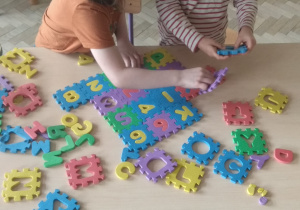 Układanie dywanika z puzzli - odnajdywanie liter i cyfr.