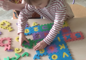 Układanie dywanika z puzzli - odnajdywanie liter i cyfr.
