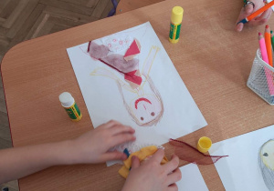 Dziecko nakleja skrawki materiału na sukienkę "Pani Wiosny".
