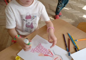 Dziewczynka nakleja skrawki materiału na sukienkę "Pani Wiosny".