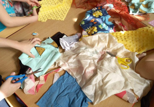 Dzieci wycinają z materiału elementy potrzebne do wykonania sukienki "Pani Wiosny"