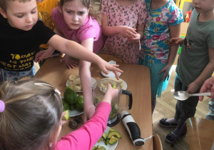 Dzieci wrzucają składniki do misy blendera.