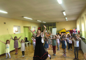Dzieci tańczą z tancerką baletową.