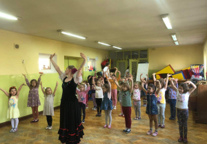 Dzieci naśladują ruchy pokazywane przez tancerkę.