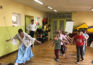 Dzieci tańczą wraz z tancerką.