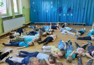 Dzieci leżą na podłodze.