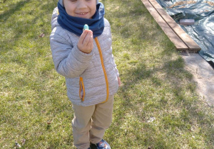 Chłopiec pokazuje znalezioną czekoladową pisankę.