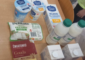 Na stole leżą produkty z mleka krowiego.