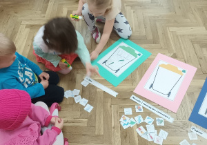 Dzieci naklejają obrazki odpadów do odpowiedniego pojemnika.