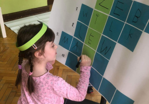 Dziewczynka wpisuje hasło do krzyżówki.