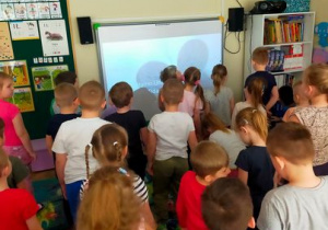 Dzieci wysłuchują hymnu polski przyjmując właściwą postawę.