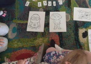 Dzieci siedzą na dywanie słuchając bajkowej zagadki.