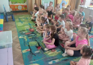 Dzieci oglądają prezentację o lecie.