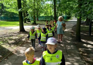 Dzieci idą przez park.