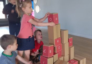 Dzieci budują fabrykę z kartonowych cegieł.