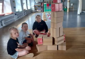 Dzieci budują fabrykę z kartonowych cegieł.