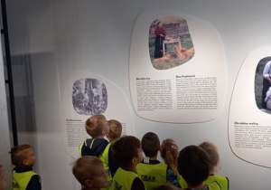 Dzieci oglądają obrazki na ścianie.