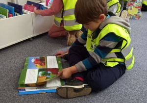 Chłopiec ogląda książkę.
