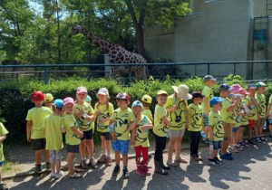 Dzieci przy wybiegu z żyrafą.