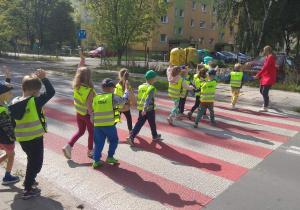 Dzieci bezpiecznie przechodzą na drugą stronę ulicy.