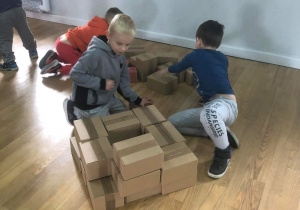 Dzieci z kartonowych pudeł budują komin