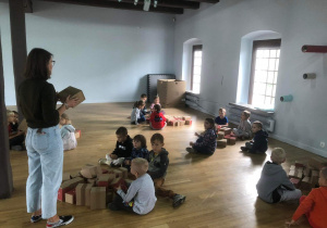 Dzieci siedzą obok kartonowych pudełek