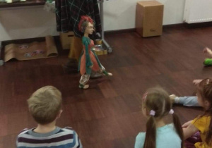 Pani pokazuje dzieciom, w jaki sposób porusza się marionetka.