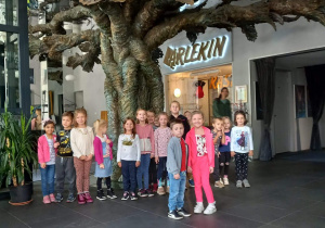 Dzieci pozują do zdjęcia pod drzewem w Teatrze Arlekin.