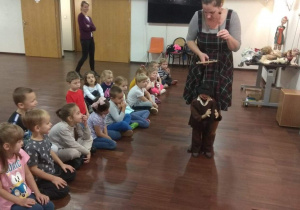 Pani pokazuje dzieciom w jaki sposób porusza się lalka teatralna.