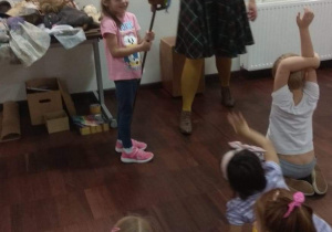 Dziewczynka próbuje poruszać teatralną lalką - krasnoludkiem.