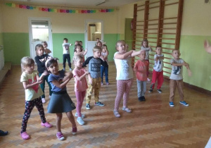 Dzieci tańczą układ charakterystyczny do muzyki.