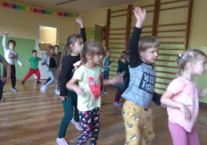 Dzieci tańczą układ charakterystyczny do muzyki.