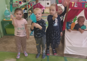 Dzieci trzymają kukiełki z warzywami.