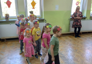 Dzieci w przedstawieniu teatralnym - idą w parach na wycieczkę, podczas której spotykają jeżyka.