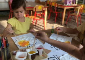 Dzieci malują jabłka przy pomocy pipety