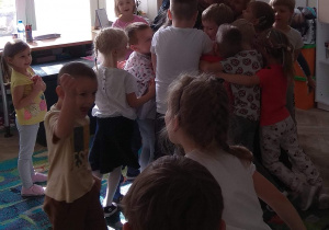 Dzieci wręczyły laurkę i przytulają się do Pani z grupy zielonej.