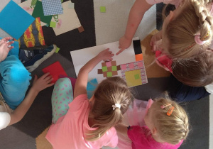 Dzieci układają wzory z wykorzystaniem różnej wielkości kolorowych kwadratów.
