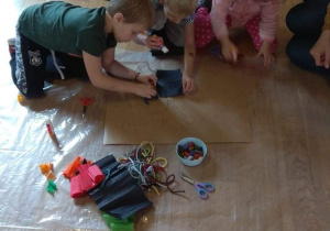 Dzieci w pracy plastycznej przekształcają odrysowane dłonie w jesienne drzewa.