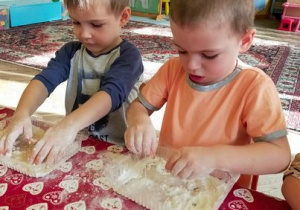 Dzieci mieszają mąkę z wodą.