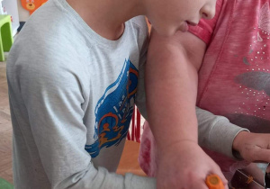 Chłopiec trze marchewkę.