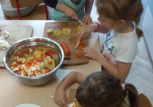 Dzieci kroją warzywa.