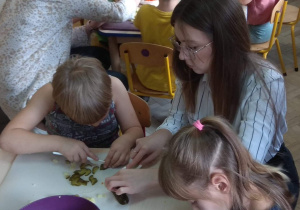 Dzieci i przybyli goście kroją warzywa na sałatkę.
