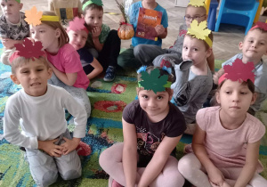 Dzieci z grupy zielonej siedzą na dywanie w klasie.