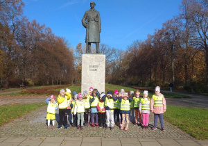 Dzieci stoją przy pomniku Legionisty.