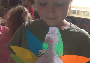 Chłopiec prezentuje swoją pracę - indyk z papieru.