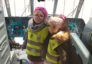 Dzieci stoją w kabinie pilota.