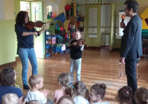 Chłopiec gra razem z panią na skrzypcach.