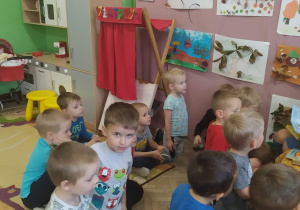 Dzieci siedzą i słuchają bajki czytanej przez mamę Rafała.